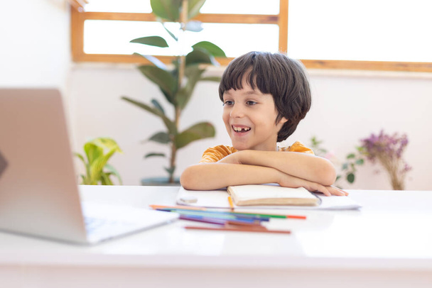 Онлайн дистанційне навчання. хлопчик з комп'ютером спілкується через відеоконференцію з вчителем і групою класів. Дитина спілкується онлайн
. - Фото, зображення