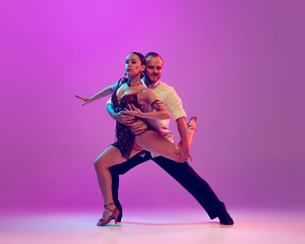Love. Feelings in dance. Emotional dancers dancing ballroom dance isolated on purple background. Concept of art, dance, beauty, music, style. Copy space for ad. International Dance Day - Photo, image