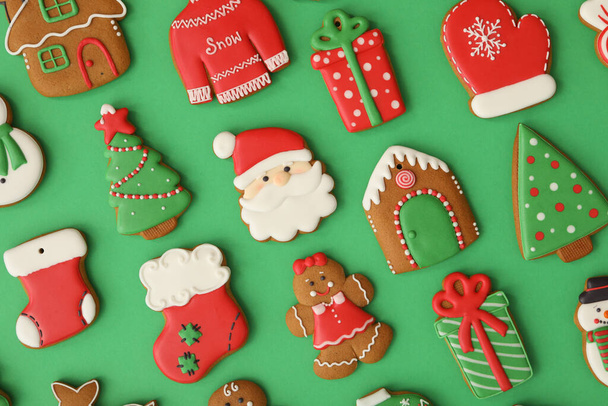 Different Christmas gingerbread cookies on green background, flat lay - Zdjęcie, obraz