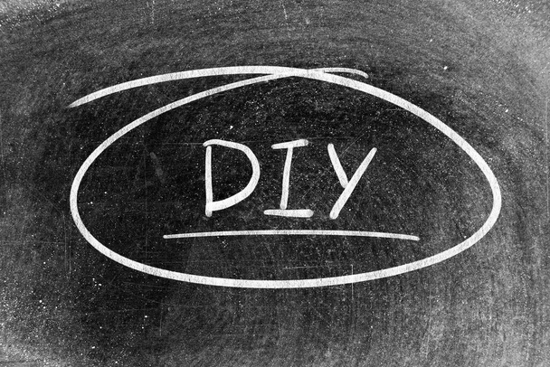 White chalk hand writing in word DIY (abbreviation of do it yourself) on blackboard background - Foto, immagini