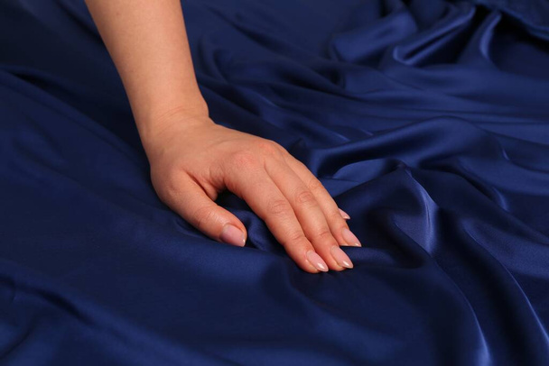 Woman touching silky blue fabric, closeup view - Фото, зображення