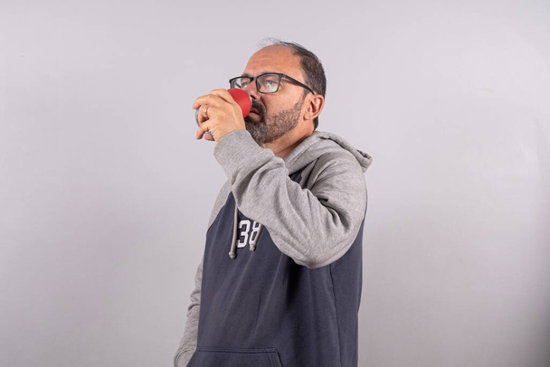 Portrait of happy senior in casual outfit and drinking soda - Foto, imagen