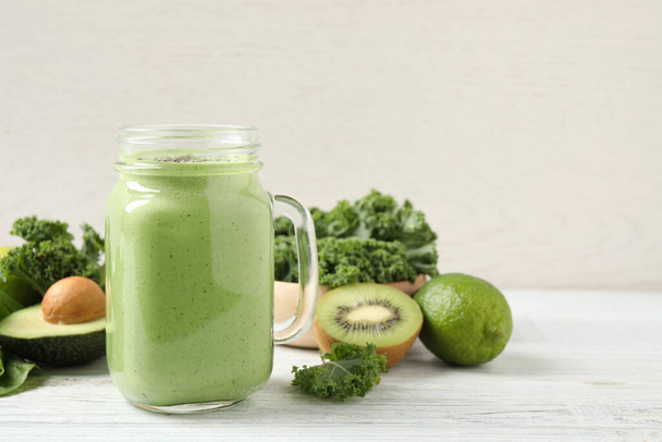 Tasty fresh kale smoothie on white wooden table - Фото, изображение