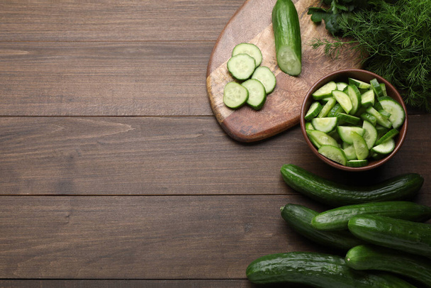 Fresh ripe cucumbers and dill on wooden table, flat lay. Space for text - Photo, Image