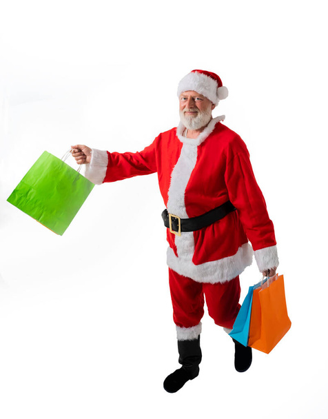 Санта-Клаус держит пакеты с подарками на Рождество на белом фоне - Фото, изображение