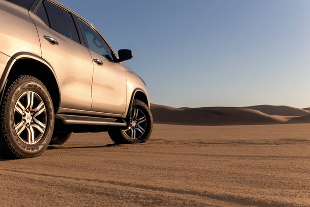 Toyota Fortuner στέκεται στη μέση της ερήμου Namib σε μια ηλιόλουστη μέρα. Ναμίμπια, Αφρική  - Φωτογραφία, εικόνα