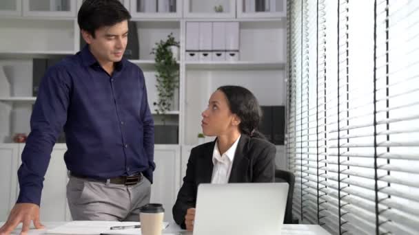Concept of experienced and competent coworker, employer, supervisor giving advice to a young female office worker. Teamwork between coworkers, leadership company, multiracial in workspace. - Filmati, video