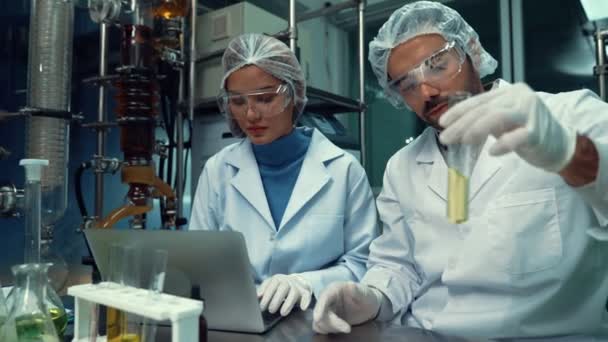Zwei Wissenschaftler in Uniform arbeiten im heilenden Labor für chemische und biomedizinische Experimente - Filmmaterial, Video