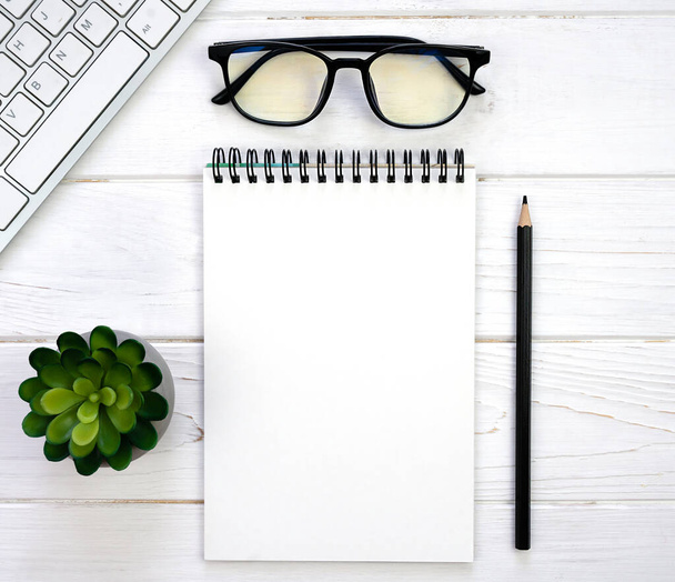 Workplace with blank notepad, glasses, pencil and keyboard. Mockup. Flatlay. Top view. Place for text. - Foto, Imagen