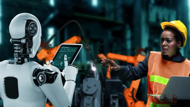 Cybernated industry robot and human worker working together in future factory . Concept of artificial intelligence for industrial revolution and automation manufacturing process . - Video