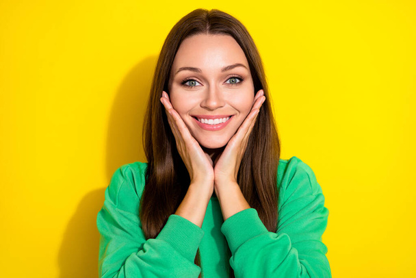 Portrait of pretty positive person arms touch cheeks have good mood isolated on yellow color background. - 写真・画像