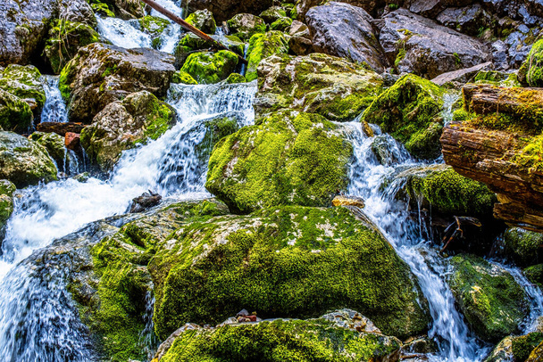 Fresh water flows over rocks & stones down a river bed, in a beautiful nature landscape - Foto, afbeelding