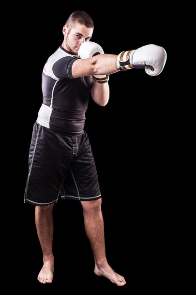 Punching boxer on black - Φωτογραφία, εικόνα