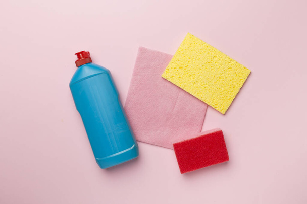 Garrafa com detergente para lavar louça e esponjas no fundo de cor, vista superior. - Foto, Imagem