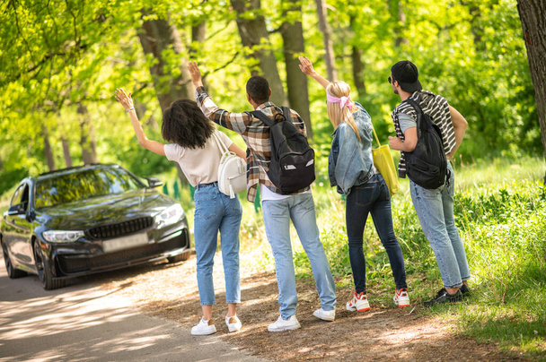 Hitchhiking. Group of young people hitchiking on the road - Foto, Imagem