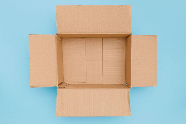 A top view of blank open cardboard box isolated on blue background - Φωτογραφία, εικόνα