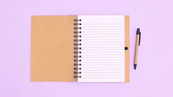Open notebook with pencil on pastel purple background. Flat lay copy space - Fotoğraf, Görsel