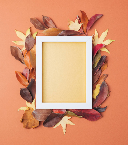 Autumn leaves arranged around rectangular frame with golden copy space. Fall season flat lay - Foto, afbeelding