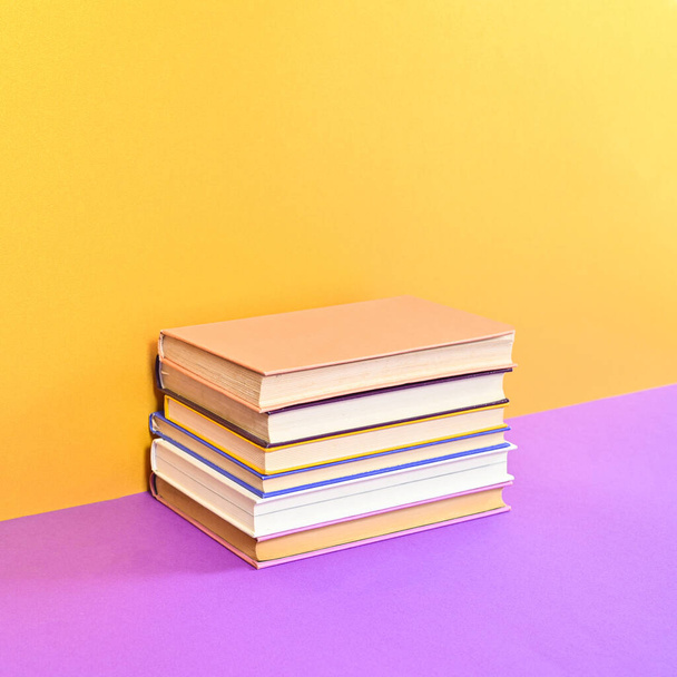 Hardcover vintage books ordered on golden purple background. Flat lay - Photo, Image