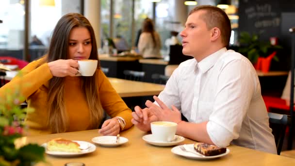 Happy couple (man and woman) drink coffee in cafe - Footage, Video