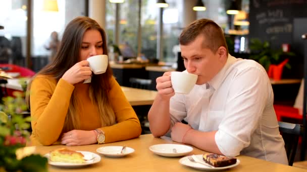 glückliches Paar trinkt Kaffee und lächelt im Café (vor der Kamera)) - Filmmaterial, Video
