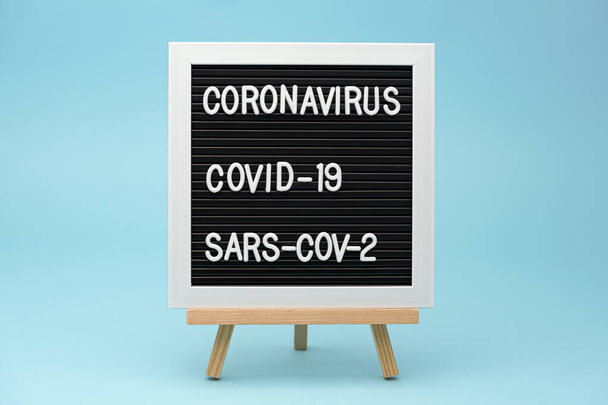 Writing board: CORONAVIRUS, COVID-19 and SARS-COV-2. isolated on blue background. Close-up. Horizontal shot. - Foto, Imagen
