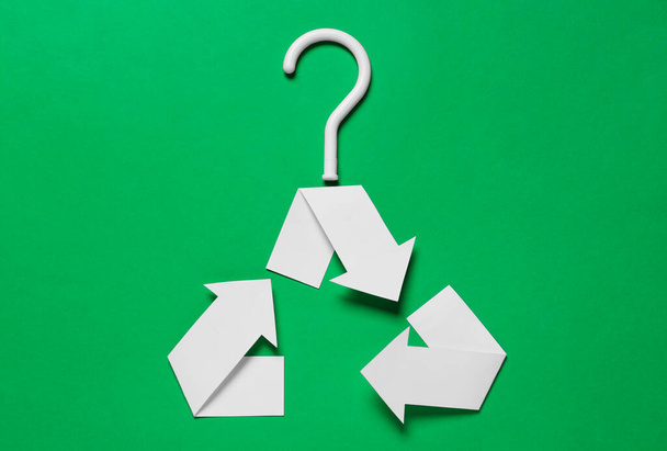 Recycling symbol in shape of hanger on green background, top view - Foto, Bild