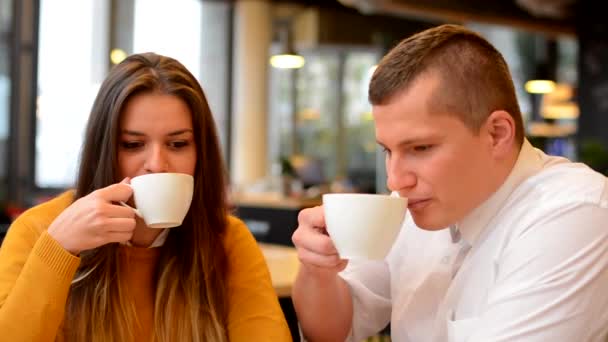 Onnellinen pari juo kahvia ja hymyilee kahvilassa (kameraan) -lähikuva
 - Materiaali, video