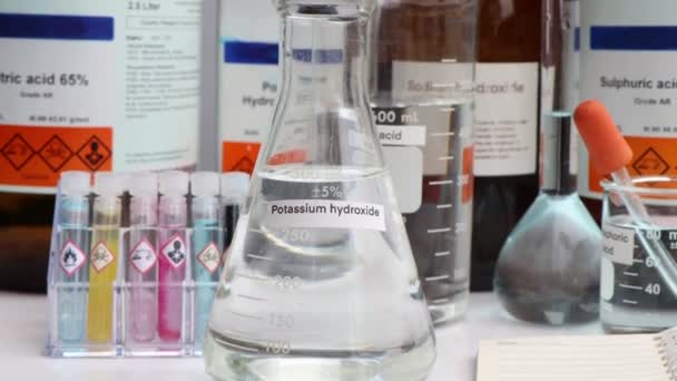 Гидроксид калия в стекле, химикаты в лаборатории и промышленности - Кадры, видео