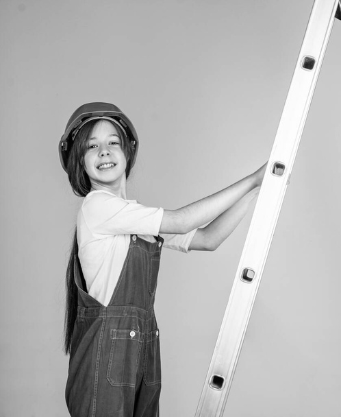 girl kid in hard hat on construction site use ladder, builder. - Foto, Imagem