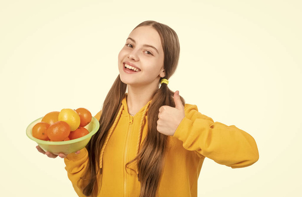 natural organic and fresh. healthy life. diet and kid skin beauty. thumb up. happy teen girl with citrus fruit plate. vitamin and dieting. child eating healthy food. childhood health. citrus fruits. - Foto, afbeelding