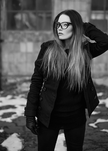 Эмотивный портрет красивой женщины-модели с длинными вьющимися волосами и темным вечерним макияжем, в черной куртке
. - Фото, изображение
