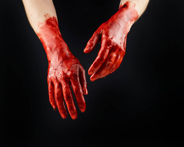 Womens hands in blood on a black background - Foto, Imagen