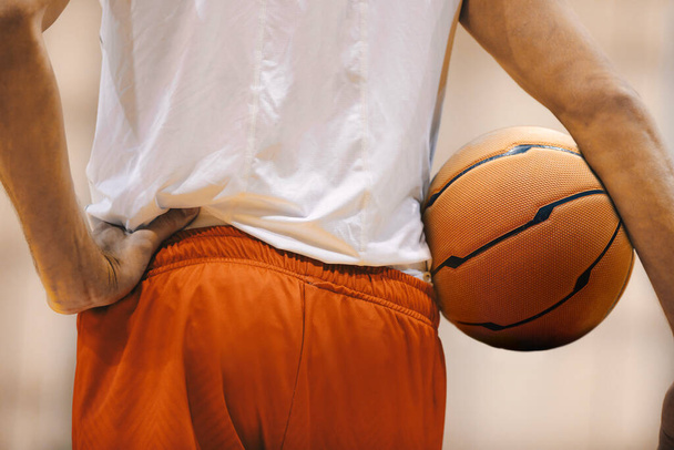 Basketball player holding game ball. Basketball training session. Closeup image of basketball - Foto, imagen