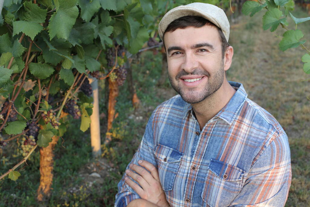 close-up portrait of handsome young man standing in grapes garden - Foto, Imagem