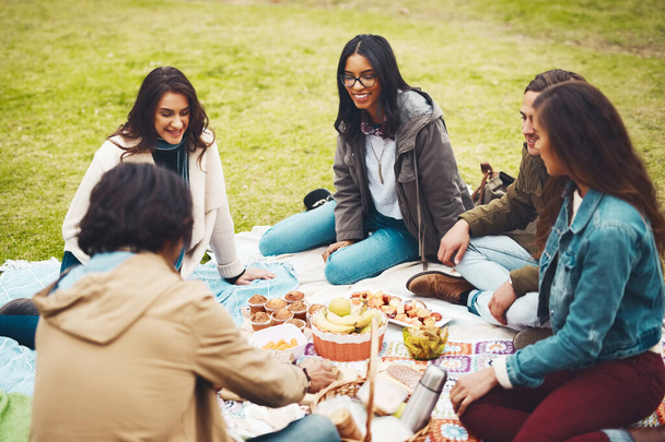 Who needs a refill. a group of cheerful young friends having a picnic together outside in a park during the day - Foto, imagen