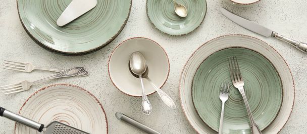 Set of clean kitchen utensils and dinnerware on light background, top view - Foto, imagen