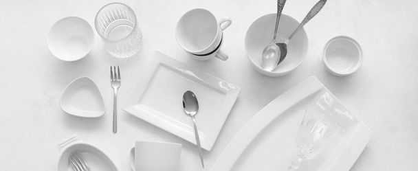 Set of clean dinnerware and cutlery on light background, top view - Foto, Imagem