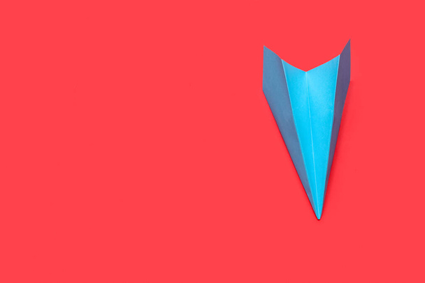 Синий бумажный самолет на красном фоне - Фото, изображение