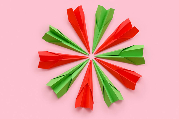 Red and green paper planes on pink background - Foto, imagen