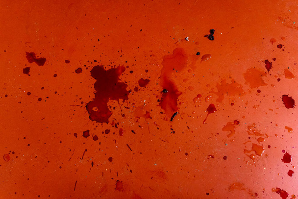 Dark red dirty stains from liquid or blood on red linoleum. - Фото, изображение