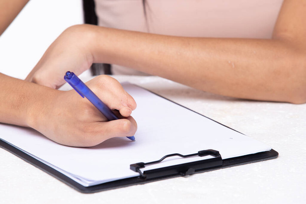 Disabled person hand without fingers since childhood brith, using pen to write word sentence on paper note. Woman use short fingers to hold pen as normal people, white background isolated copy space - Foto, Imagen