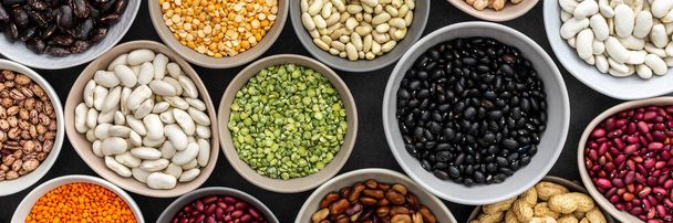 Banner of different types of legumes in bowls, green with yellow peas and mung beans, chickpeas and peanuts, colored beans and lentils, top view - Foto, Imagem