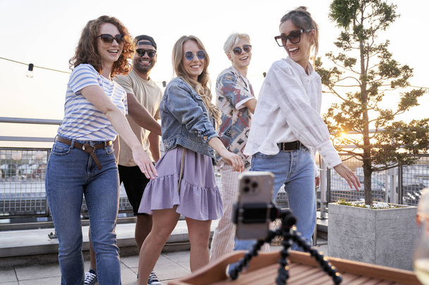 Group of friends recording dances at mobile phone at the rooftop - Foto, imagen