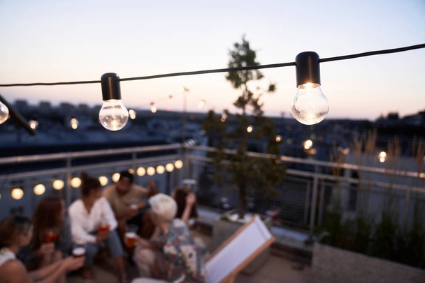 Close up of lamp bulb at the rooftop party in city - Foto, Imagen