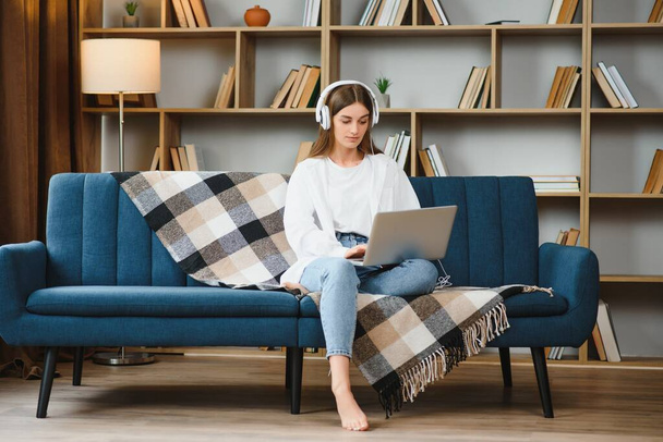 Woman freelancer working with laptop at home on sofa. Working girl portrait. - Фото, зображення