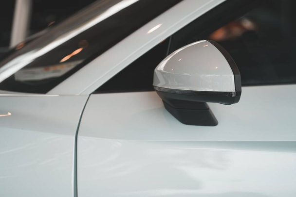 A closeup shot of a white cars rearview mirror - Photo, image