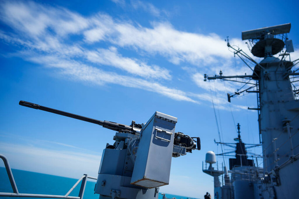 Color image of an automated machine gun on the deck of a military ship, at sea. - Foto, afbeelding