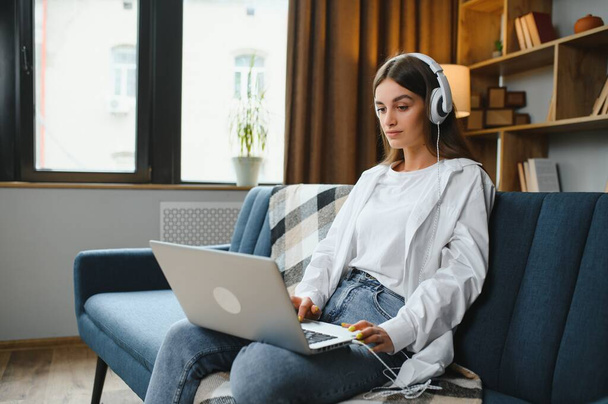Woman freelancer working with laptop at home on sofa. Working girl portrait. - Foto, imagen