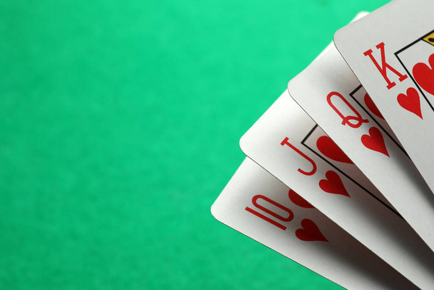 Hand of playing cards on green background, closeup. Space for text - Valokuva, kuva